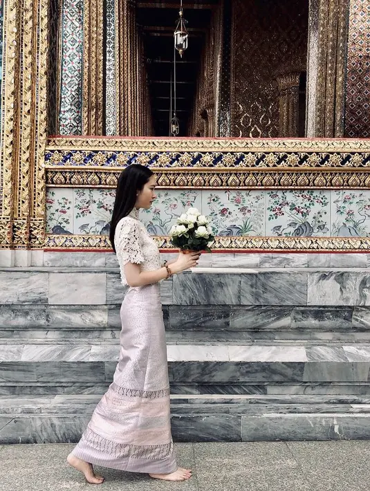 Atasan dengan material lace dan kain songket Thailand dipakai Nong Poy saat berdoa di kuil. [@poydtreechada]
