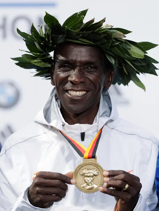 Pelari Kenya, Eliud Kipchoge menunjukkan medali emasnya saat memenangkan Berlin Marathon ke-45 di Berlin, Jerman, Minggu (16/9). Berlin Marathon menjadi ajang lari marathon kesembilan yang ia menangkan secara beruntun. (AP Photo/Markus Schreiber)