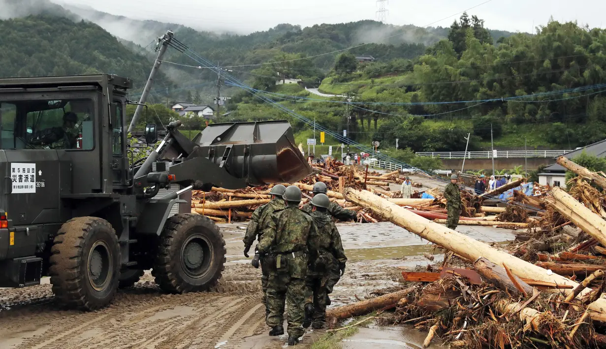 Pasukan Bela Diri Jepang membersihkan puing yang disebabkan hantaman banjir di daerah Asakura, prefektur Fukuoka, Kamis (6/7). Hujan lebat yang disertai angin kencang menyebabkan sejumlah sungai meluap di selatan Jepang. (Sadayuki Goto/Kyodo News via AP)