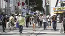 Orang-orang yang memakai masker untuk membantu mengekang penyebaran virus corona COVID-19 berjalan di jalan di Tokyo, Jepang, Jumat (6/8/2021). Tokyo berada dalam keadaan darurat virus corona COVID-19 sejak pertengahan Juli. (AP Photo/Kantaro Komiya)