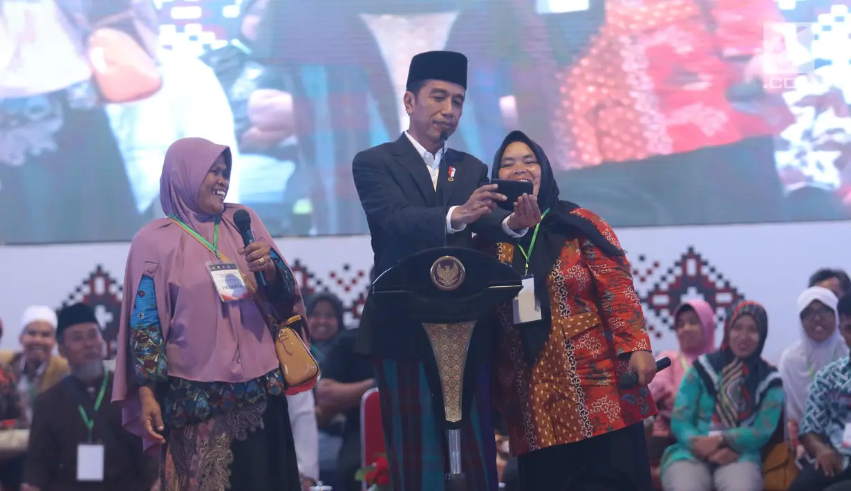 Presiden Jokowi berselfie dengan warga di Pondok Pesantren Miftahul Huda, Tasikmalaya, Jawa Barat, Rabu (27/2). Kedatangan Jokowi merupakan bagian dari rangkaian Penyaluran KUR Ketahanan pangan dan aksi ekonomi untuk rakyat. (Liputan6.com/Angga Yuniar)