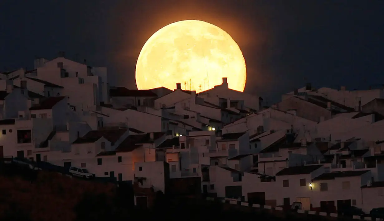 Bulan purnama tampak dari atap sebuah di Olivera, Spanyol Selatan.   Bulan terlihat lebih besar dari biasanya karena pada saat ini bulan   berada pada titik yang terdekat dengan bumi (REUTERS/Jon Nazca)