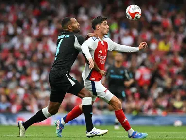 Gelandang Arsenal Kai Havertz berebut bola dengan bek Bayer Leverkusen Odilon Kossounou dalam duel pramusim 2024 di Emirates Stadium, Kamis (8/8/2024) dini hari WIB. (Glyn KIRK / AFP)