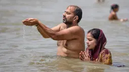 Umat Hindu berdoa di Sungai Gangga, selama festival Ganga Dussehra, di Prayagraj, India (1/6/2020). Ratusan umat Hindu melakukan pencucian suci meskipun jemaat di tempat-tempat keagamaan terus dilarang selama penguncian coronavirus nasional. (AP Photo/Rajesh Kumar Singh)