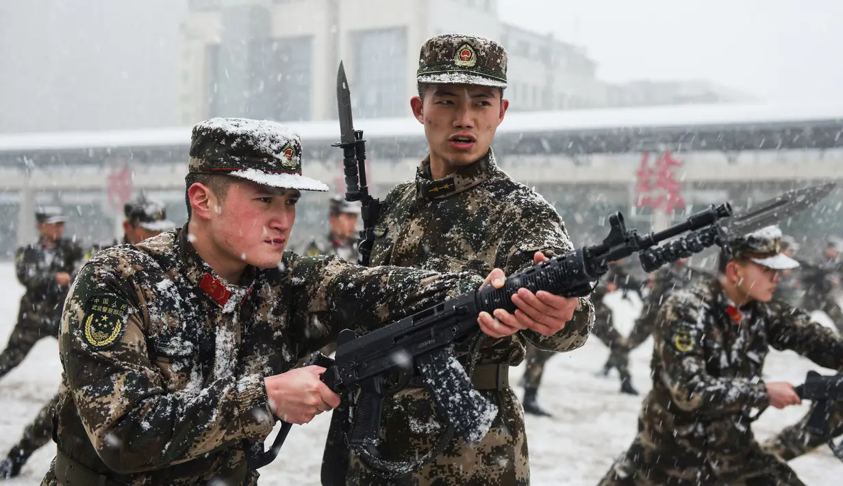 Polisi militer saat mengikuti sesi pelatihan menggunakan senapan berpisau di tengah hujan salju di Hefei, China (15/1/2020). Latihan fisik yang dilakukan anggota polisi militer China meliput angkat ban traktor hingga teknik menyerang dengan menggunakan senapan berpisau. (AFP Photo/Str/China Out)