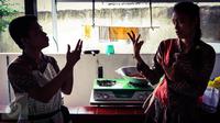 Dua orang pegawai berbincang dalam bahasa isyarat di kafe Finger Talk, Pamulang, Tangsel, Sabtu (20/2). Sang pemilik, Dissa, mendapatkan ide membangun kafe ini setelah melihat konsep yang sama di Nikaragua, Amerika. (Liputan6.com/Fery Pradolo)