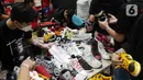 Pengunjung memilih produk yang ditawarkan di Urban Sneaker Society 2021 di JCC, Senayan, Jakarta, Minggu (5/12/2021). Acara menghadirkan kegiatan NFT Gallery, Sneaker Museum dan juga Raffle yang menjadi salah satu daya tarik Urban Sneaker Society dari tahun ke tahun. (Liputan6.com/Herman Zakharia)