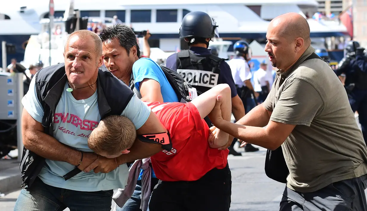 Seorang fans Inggris ditahan oleh polisi menyusul bentrokan antara fans Inggris dan polisi di kota Marseille, Prancis (11/6/2016). Bentrok terjadi menjelang pertandingan sepak bola Euro 2016 antara Inggris dan Rusia. (AFP Photo/Leon Neal)