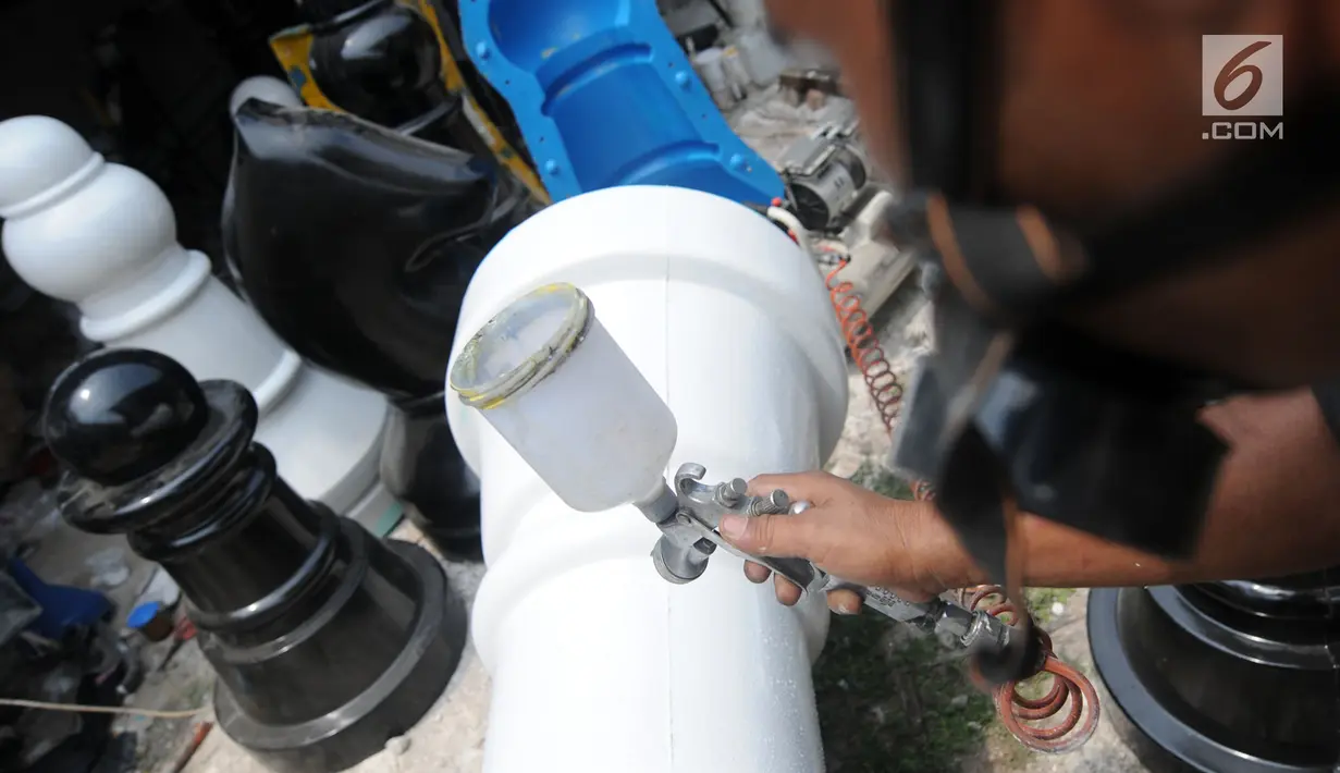 Perajin melakukan pengecatan saat pembuatan bidak catur raksasa di kawasan Pondok Aren, Tangerang Selatan, Selasa (16/10). Catur raksasa setinggi hampir satu meter ini dipasarkan di wilayah Jabodetabek hingga Kalimantan dan Bali. (Merdeka.com/Arie Basuki)