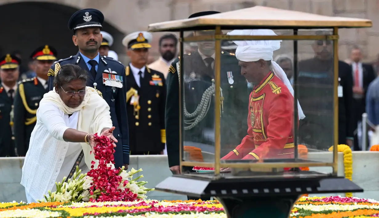 Presiden India, Droupadi Murmu menebarkan kelopak bunga mawar di tugu peringatan Mahatma Gandhi di Rajghat pada hari ulang tahun kematian Gandhi di New Delhi, India, Senin (30/1/2023). Gandhi meninggal dunia di usia 78 tahun, peringatan kematian Gandhi, yang secara luas dikenal di India dan diperingati sebagai Hari Martir. (Sajjad HUSSAIN/AFP)