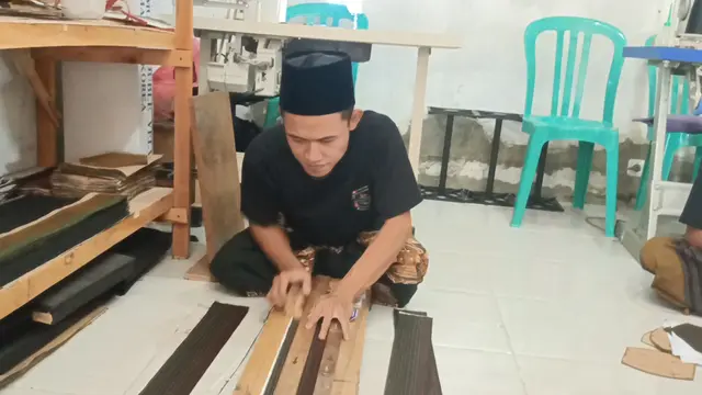 Salah satu santri alumni Ponpes Bumi Damai Al Mustawa ketika memproses pembuatan peci hitam. (Liputan6.com/Ahmad Adirin)