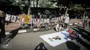 Warga menandatangani kain putih sebagai dukungan saat aksi 'Kami Sayang Badak' pada Car Free Day di kawasan Bunderan HI, Jakarta, (27/3). Aksi tersebut guna Memperingati hari bumi dan kampanye Badak yang hampir punah. (Liputan6.com/Faizal Fanani)