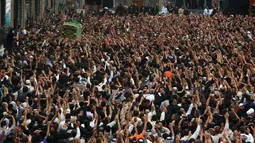 Ribuan umat Syiah Irak menyaksikan peti jenazah yang menyimbolkan Musa al-Kadhim di Kadhimiya, distrik utara Baghdad, Irak (23/4). Ribuan peziarah mendatangi tempat tersebut untuk memperingati wafatnya Musa al-Kadhim. (AFP/Sabar Arar)