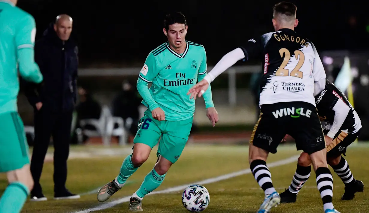 Gelandang Real Madrid, James Rodriguez berebut bola dengan bek Unionistas de Salamanca, Juan Gongora pada babak ke-32 besar Copa del Rey 2019-2020 di Pistas del Helmantico, Rabu (22/1/2020). Madrid harus berjuang keras untuk menang 3-1 atas tim divisi tiga, Unionistas. (JAVIER SORIANO/AFP)