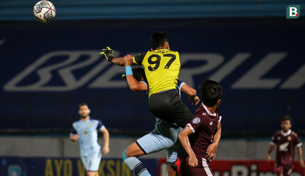 Kiper PSM Makassar, Hilman Syah (atas) berusaha menghalau bola dari ancaman pemain Persela Lamongan dalam laga pekan ke-15 BRI Liga 1 2021/2022 di Stadion Moch. Soebroto, Magelang, Kamis (02/12/2021). (Bola.com/Bagaskara Lazuardi)
