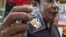Seorang pedagang emas menunjukkan batangan emas kepada pelanggan di sebuah toko emas di Jakarta pada Jumat 29 Mei 2026. (BAY ISMOYO/AFP)