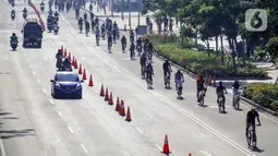 Warga berolahraga menggunakan sepeda di sepanjang Jalan Sudirman, Jakarta, Minggu (26/7/2020). Pemprov DKI Jakarta akan memperluas jalur sepeda sementara yang disiapkan sepanjang Jalan Medan Merdeka Barat hingga Jalan Sudirman dengan memakai 2-3 lajur di sebelah kiri. (Liputan6.com/Faizal Fanani)