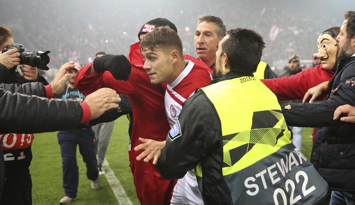 Para pemain Olympiakos, Leonardo Koutris, meninggalkan lapangan usai merayakan kemenangan atas AC Milan pada laga Europa di Stadion Georgios Karaiskakis, Athena, Kamis (13/12). Olympiakos menang 3-1 atas AC Milan. (AP/Thanassis Stavrakis)