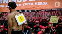 Massa yang tergabung dalam Partai Buruh melakukan aksi teatrikal saat menggelar aksi di depan Gedung DPR, Jakarta, Selasa (6/9/2022). Dalam aksi tersebut mereka menolak keputusan pemerintah menaikkan harga bahan bakar minyak (BBM) bersubsidi dan meminta pemerintah untuk meninjau ulang keputusan tersebut. (Liputan6.com/Faizal Fanani)