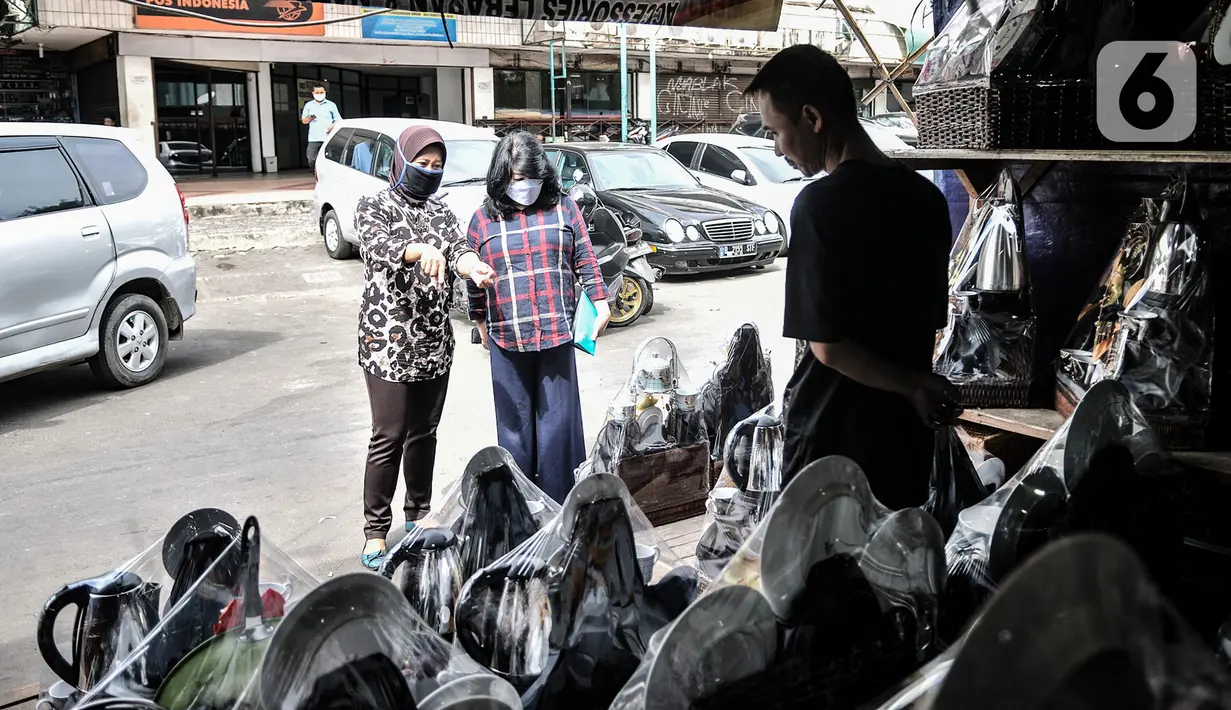Pedagang parsel saat melayani pembeli di kawasan Cikini, Jakarta, Selasa (29/12/2020). Menurut salah satu pedagang, Dede (48), pandemi COVID-19 mengakibatkan penjualan parsel selama Natal dan jelang Tahun Baru merosot drastis dibandingkan tahun lalu. (merdeka.com/Iqbal S. Nugroho)