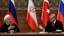 Presiden Turki Recep Tayyip Erdogan (kanan) dan Presiden Iran Hassan Rouhani (kiri) saat konferensi pers di Ankara, Turki, Rabu (4/4). Pertemuan ketiganya menghasilkan komitmen untuk mencapai gencatan senjata abadi di Suriah. (AFP PHOTO/ADEM ALTAN)