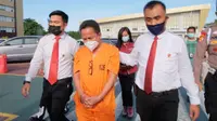 Personel Direktorat Reserse Kriminal Khusus Polda Riau mengiring Kepala Dinas Kesehatan Kepulauan Meranti. (Liputan6.com/M Syukur)