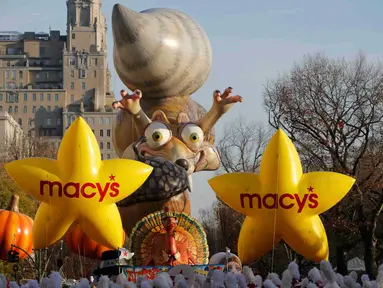 Balon berukuran besar mengiringi parade Hari Pengucapan Syukur Macy's di Manhattan borough,  New York, Kamis (26/11). Parade ini pertama kali diadakan pada tahun 1924. (REUTERS/Andrew Kelly)