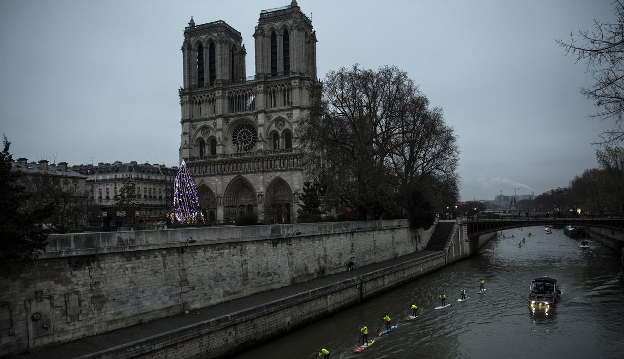 Peserta mendayung sambil berdiri selama mengikuti Nautic SUP Paris di sepanjang sungai Seine, Paris, Prancis, Minggu (3/12). Nautic SUP Paris merupakan lomba dayung sambil berdiri terbesar di dunia. (AFP PHOTO/CHRISTOPHE SIMON)