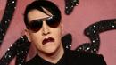 Pose Marilyn Manson saat menghidiri di Fashion Awards 2016 di London, Inggris (5/12). Mantan pacar Evan Rachel Wood tersebut tampil Fashionable dengan Jas dan kacamata hitam dengan gigi dan cincin ditangannya. (REUTERS/Neil Balai)