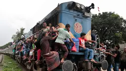 Sejumlah penumpang saat menaiki kereta api di Dhaka, Bangladesh, (22/6). Ribuan yang bekerja di Dhaka pulang ke kampung halamannya untuk merayakan lebaran bersama keluarganya. (AP Photo/A.M.Ahad)