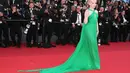 Julia Garner tiba di red carpet Cannes Film Festival 2023 dibalut gaun berwarna hijau. Gaun ini memiliki detail cross-neck dan train yang menjuntai panjang, tampilan khas princess. Foto: Instagram.