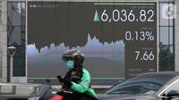 Pengendara sepeda motor melintas dekat layar pergerakan Indeks Harga Saham Gabungan (IHSG) di Jakarta, Kamis (10/10/2019). IHSG ditutup melemah 0,09 persen atau 5,52 poin ke level 6.023,64 dari penutupan perdagangan sebelumnya. (Liputan6.com/Angga Yuniar)