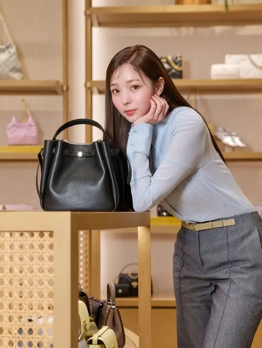 Ia pun memamerkan tas hitam handbagnya. Wajahnya tampil dengan riasan yang tidak berbeda dari penampilan sebelumnya.  [Tory Burch]