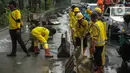 Petugas Sudin Bina Marga merapikan separator busway yang berserakan pascabanjir di Jalan Daan Mogot, Cengkareng, Jakarta, Jumat (3/1/2020). Separator busway tersebut berantakan akibat banjir yang menerjang sejak kemarin. (Liputan6.com/Faizal Fanani)