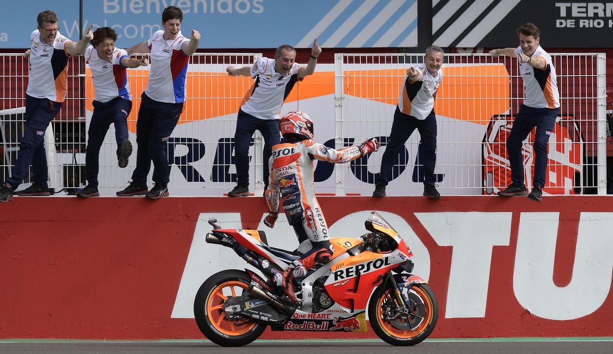 Marc Marquez merayakan kemenangannya di GP Argentina, Sirkuit Termas de Rio Hondo dengan berdiri di atas motornya menyambut rekan setimnya. (AFP/Juan Mabromata)