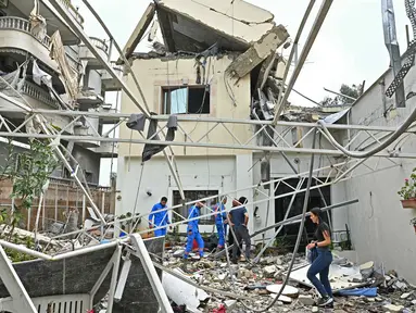Warga memeriksa puing-puing bangunan yang hancur setelah kembali ke kota Nabatieh, Lebanon Selatan pada Sabtu 18 April 2026. Warga Lebanon, khususnya di wilayah selatan, mulai berbenah. (FADEL itani/AFP)