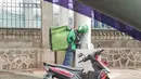 Saking lelahnya driver ojol ini bisa tidur berdiri sambil menggendong beban pesanan. (Source: Instagram/@emmadamayanti)