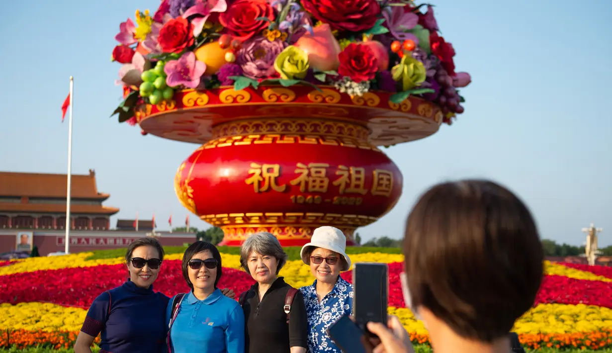 Para wisatawan berfoto di depan "keranjang bunga" di Lapangan Tian'anmen di Beijing, ibu kota China (24/9/2020). Dekorasi setinggi 18 meter berbentuk keranjang bunga itu ditempatkan di tengah Lapangan Tian'anmen untuk menyambut masa libur Hari Nasional China mendatang. (Xinhua/Chen Zhonghao)