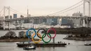 Kapal tongkang membawa Cincin Olimpiade dekat Rainbow Bridge di Distrik Odaiba, Tokyo, Jepang, Jumat (17/1/2020). Cincin Olimpiade dengan tinggi 15,3 meter dan panjang 32,6 meter tersebut akan berada di sana hingga Olimpiade 2020 berakhir. (AP Photo/Jae C. Hong)