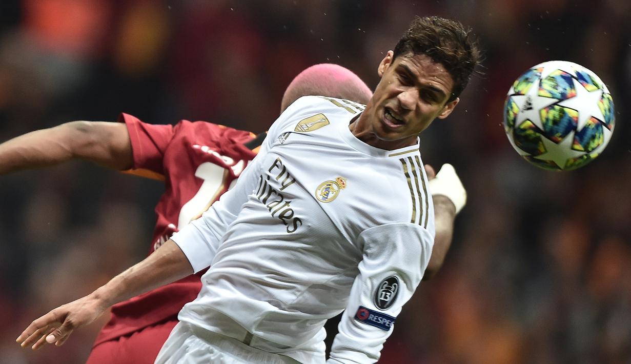 Bek Real Madrid, Raphael Varane, duel udara dengan striker Galatasaray, Ryan Babel, pada laga Liga Champions di Stadion Ali Sami Yen Spor, Istanbul, Selasa (22/10). Galatasaray kalah 0-1 dari Madrid. (AFP/Ozan Kose)