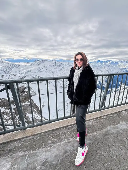 Ia juga tampil dengan jaket hitam berbulu dipadukan syal abu-abu, rok kulit dan celana ketat hitamnya. Dipadukan sneaker putihnya. [@happy_asmara77]