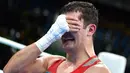 Atlet tinju Uzbekistan, Rustam Tulaganov menangis sambil menutupi wajahnya dengan tangan usai menang atas petinju Azerbaijan, Abdulkadir Abdullayev dalam pertandingan tinju putra kelas 91 kg di Olimpiade Rio 2016, 10 Agustus 2016. (AFP PHOTO/Yuri CORTEZ)