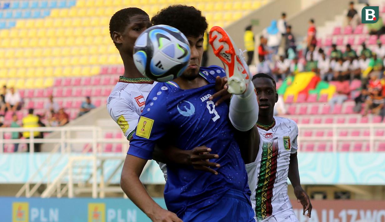 <p>Pemain Timnas Mali U-17, Issa Traore (kiri), berebut bola dengan pemain Uzbekistan U-17, Amirbek Saidov (kanan), dalam pertandingan penyisihan Grup B Piala Dunia U-17 2023 di Stadion Manahan, Solo, Jumat (10/11/2023). (Bola.com/Arief Bagus)</p>