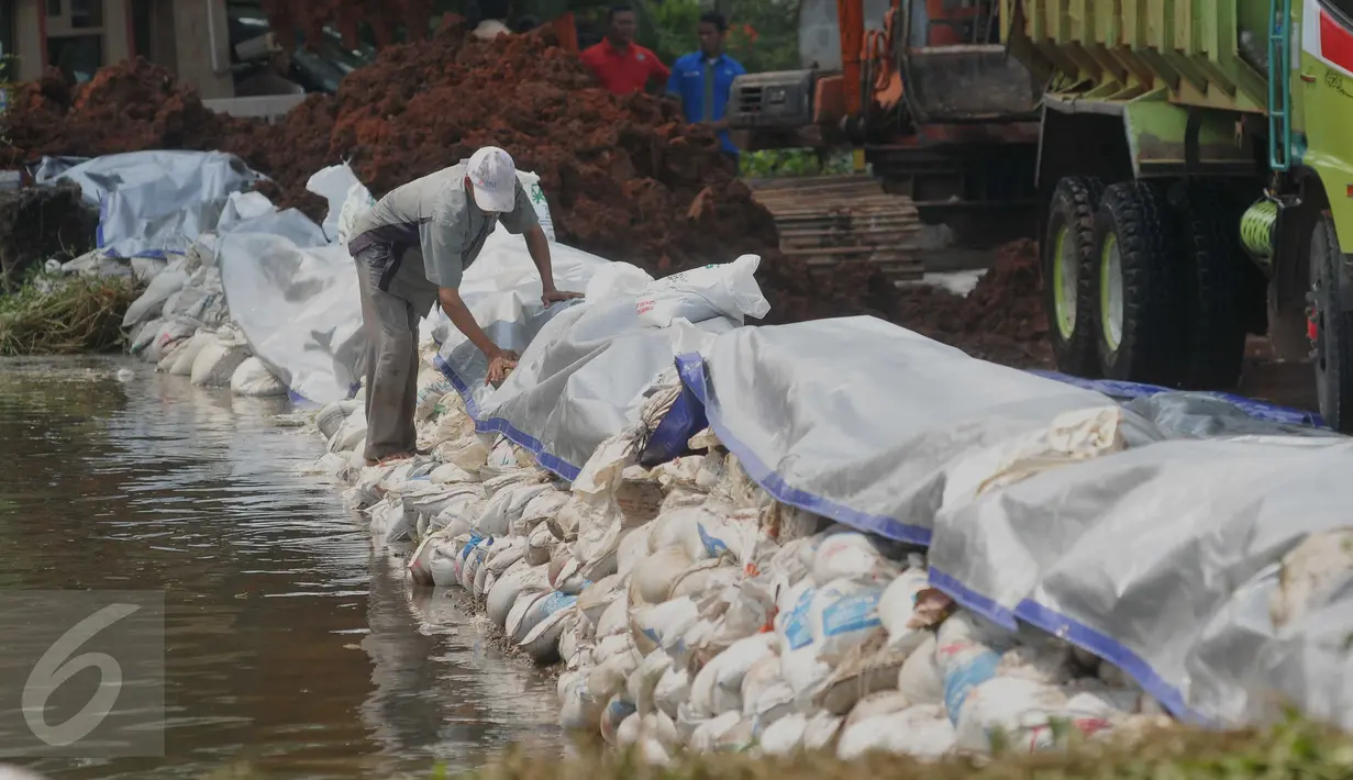 Warga saat membantu membetulkan tanggul di kawasan Perumahan Pantai Mutiara, Jakarta, Sabtu (4/6). Tingginya pasang air laut menyebabkan tanggul di Jalan Mutiara 1, Pluit, Penjaringan, sepanjang sekitar 50 meter jebol. (Liputan6.com/Gempur M Surya)