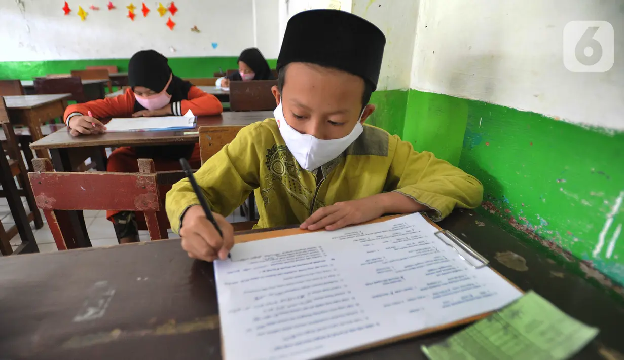 Murid kelas V mengikuti ujian Penilaian Akhir Semester (PAS) tahun pelajaran 2020/2021 di Madrasah Ibtidayah (MI) Assu'ada di Pancoran Mas, Depok, Jawa Barat, Selasa (1/12/2020). Ujian dilaksanakan dengan menerapkan protokol kesehatan dalam kelas. (merdeka.com/Arie Basuki)