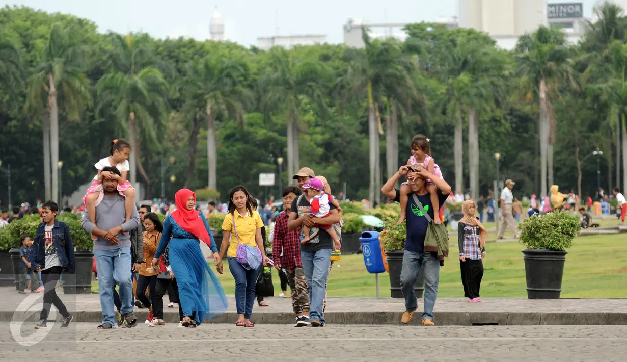 Rombongan warga berjalan-jalan di kawasan Monumen Nasional, Jakarta, Minggu (25/12). Libur perayaan Natal 2016 dimanfaatkan sejumlah warga untuk berwisata di kawasan Monumen Nasional. (Liputan6.com/Helmi Fithriansyah)