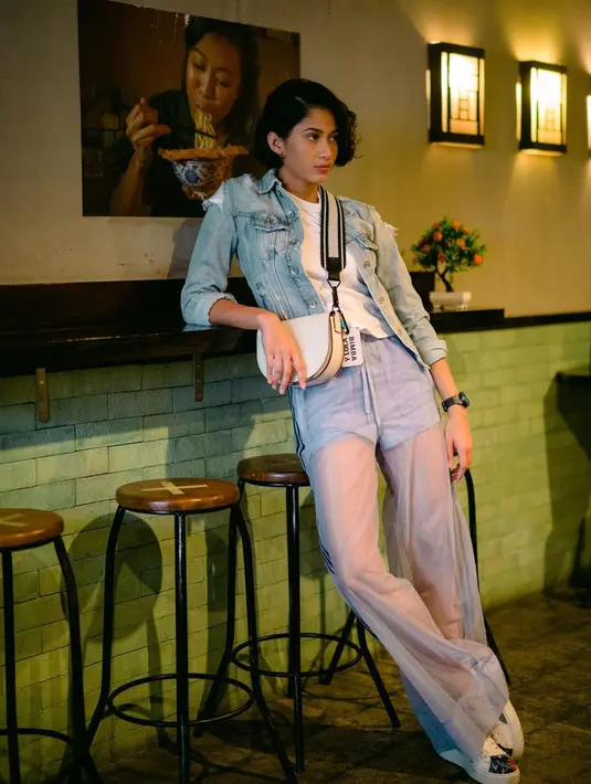 Aghniny juga tampil swag saat hangout. Ia memilih memakai kaus putih yang dibalut dengan jaket denim. Kemudian, wanita 25 tahun ini mengenakan celana panjang yang transparan pada bagian bawahnya. Penampilannya makin keren dengan jam tangan hitam, tas dan sneakers putih. (Liputan6.com/IG/@aghninyhaque)