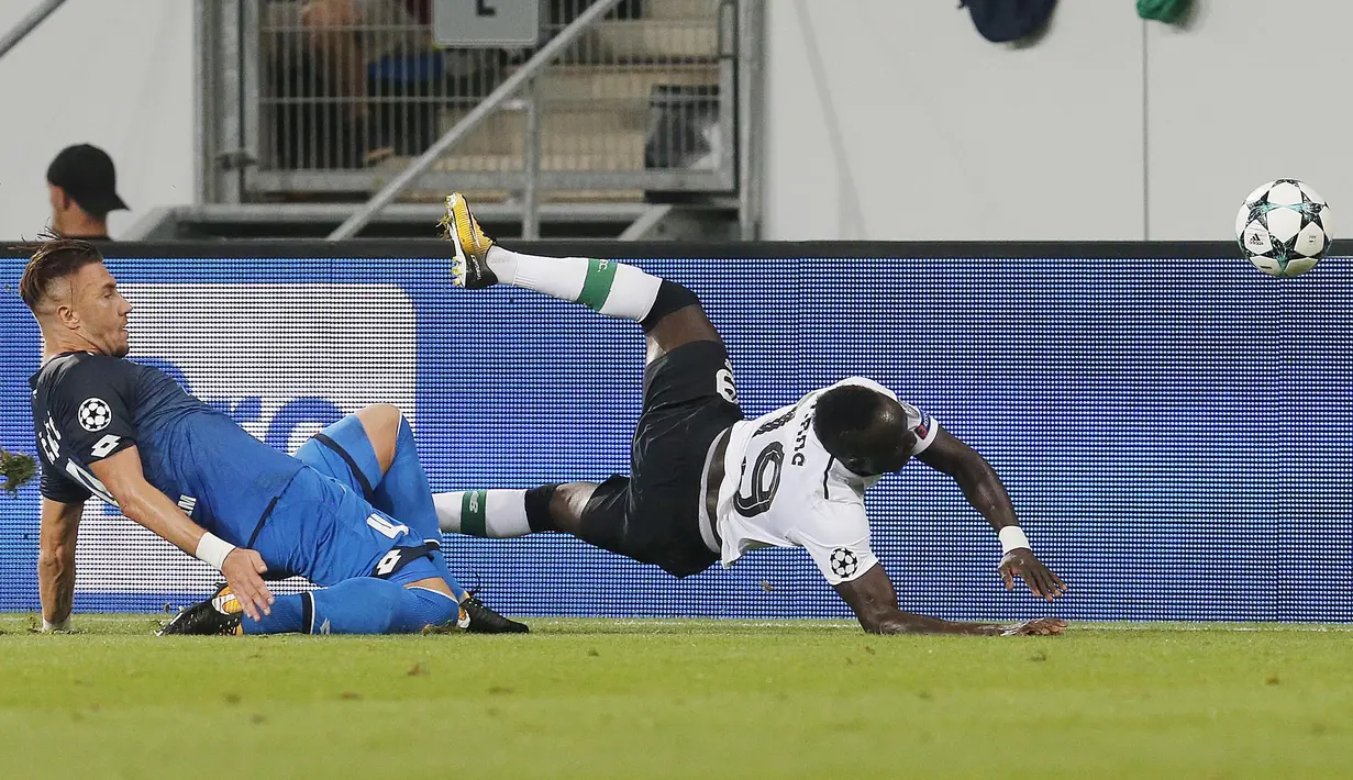 Pemain Hoffenheim, Ermin Bicakcic (kiri) melanggar pemain Liverpool, Said Mane pada kualifikasi Liga Champions di Rhein-Neckar-Arena, Sinsheim, (15/8/2017). Liverpool menang 2-1.  (AP/Michael Probst)
