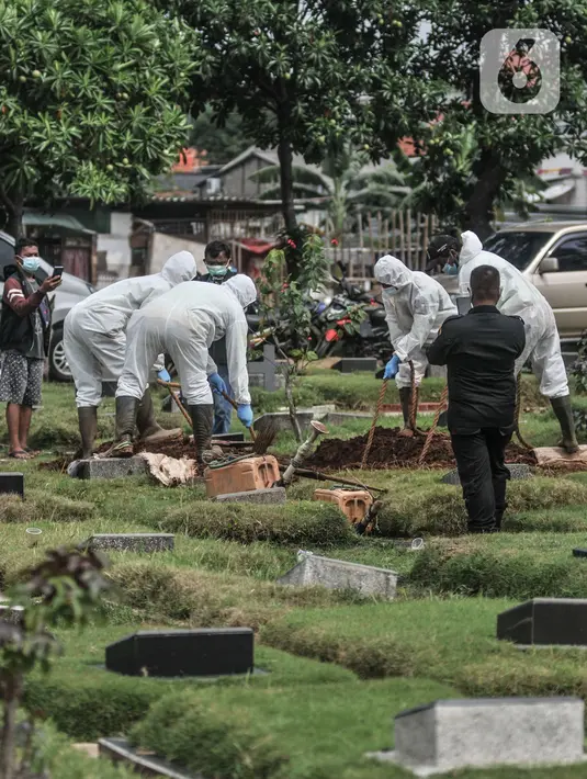 Proses pemakaman pasien Covid-19 isolasi mandiri di TPU Pondok Kelapa, Jakarta, Selasa (13/7/2021). Para pasien isolasi mandiri ini meninggal karena berbagai alasan, mulai dari terlambat mendapatkan pertolongan, rumah sakit penuh hingga tidak terpantau dengan baik. (merdeka.com/Iqbal S Nugroho)