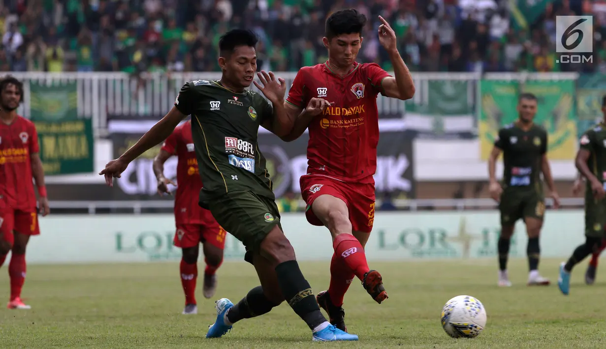 Bek Tira Persikabo, Vava Mario, berebut bola dengan gelandang Kalteng Putra, Fajar Handika, pada laga Shopee Liga 1 di Stadion Pakansari, Bogor, Jumat (26/7). Tira Persikabo menang 5-2 atas Kalteng. (Bola.com/Yoppy Renato)